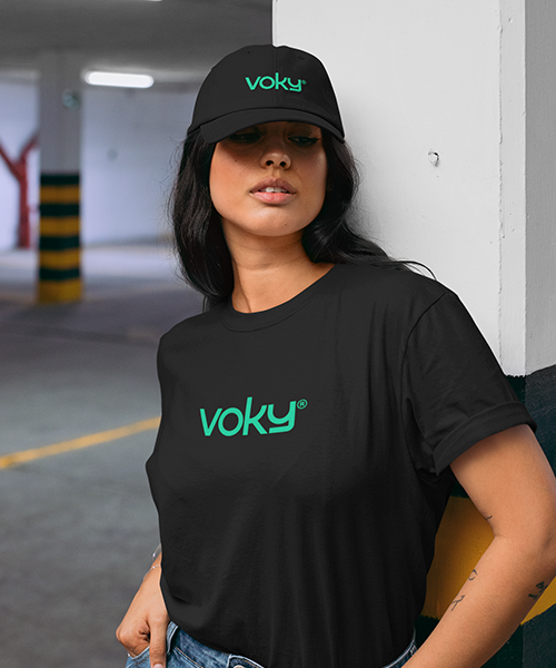 En ung kvinna i ett garage bär kläder med varumärket Voky